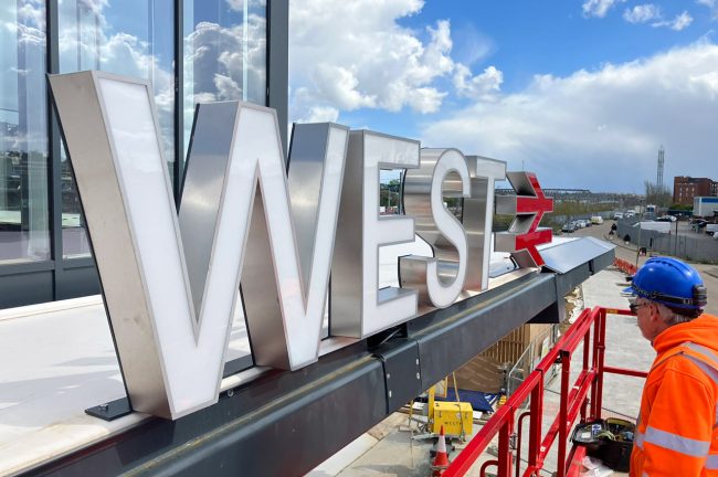 Image of station signage being erected at Brent Cross West station