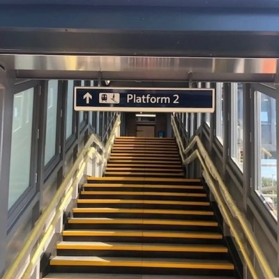 signage suspended over railway station stairs