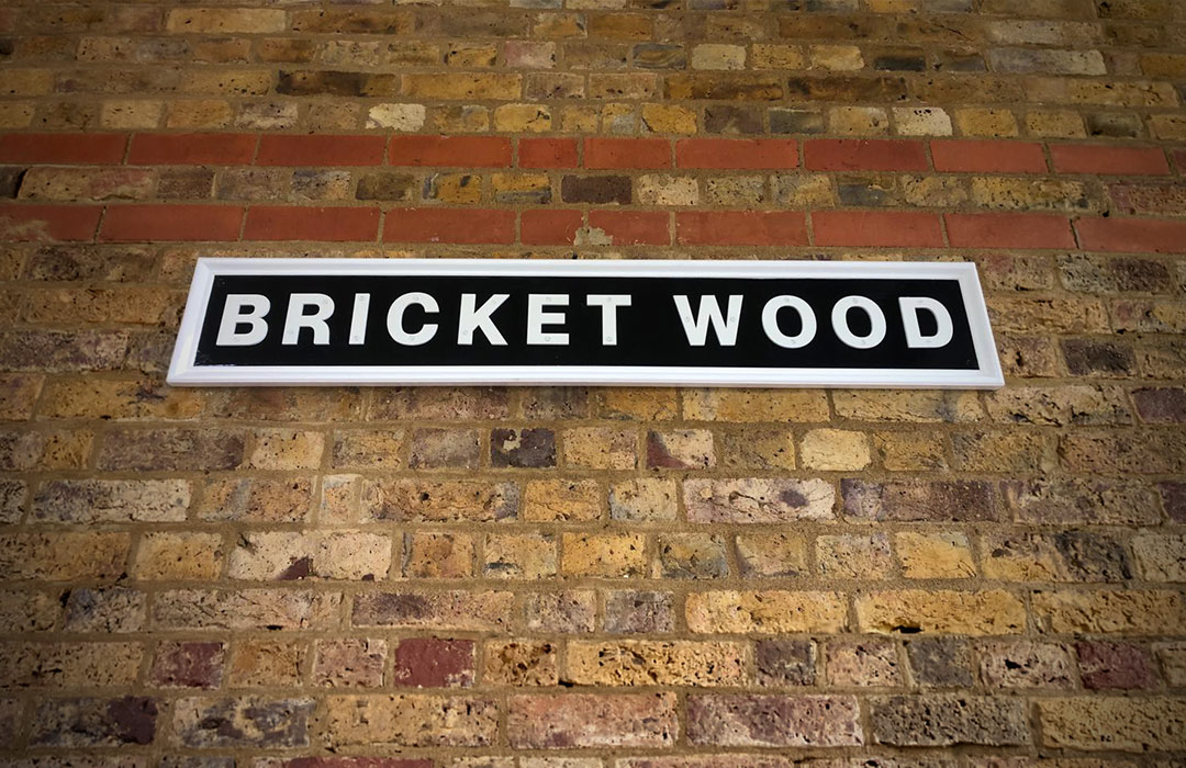 Black and white Bricket Wood sign hung on London brick